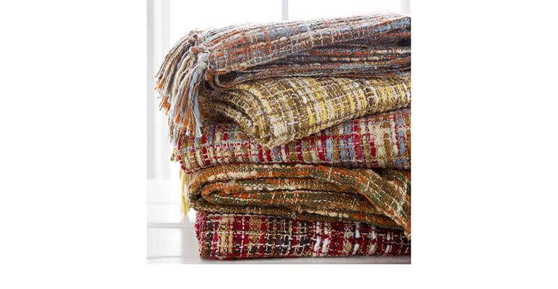 A stack of warm plaid blankets by Surya